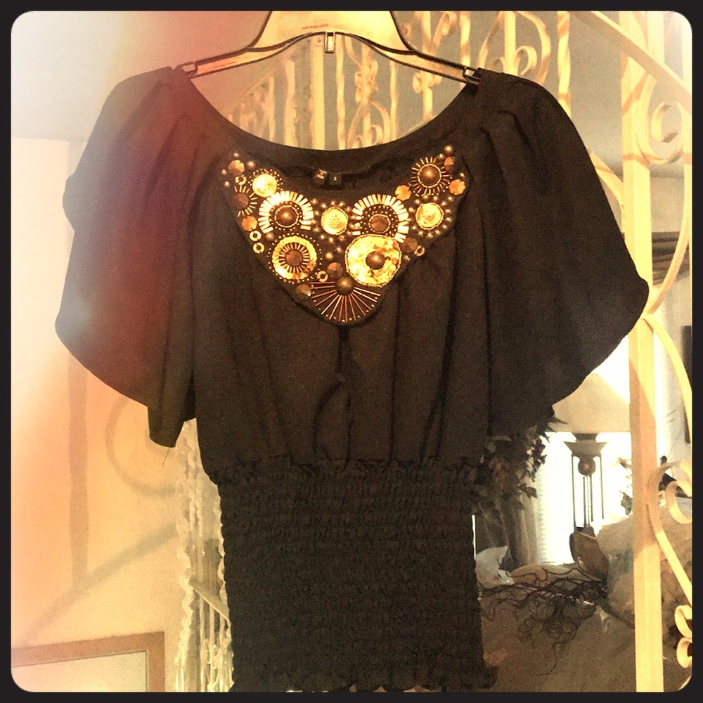 Black silky blouse with gold embellishments.
